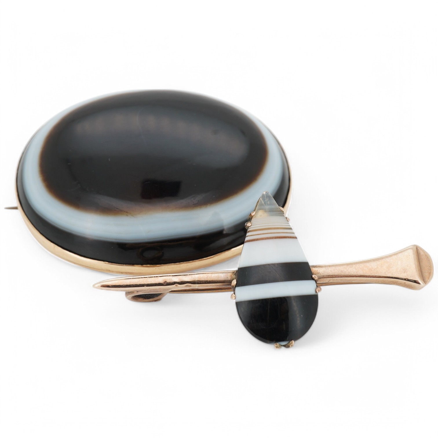 A yellow metal mounted banded agate oval brooch, 41mm, together with a yellow metal and banded agate set bar brooch. Condition - fair to good